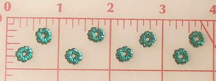 These are little vintage green glass flowers from Czechoslovakia.